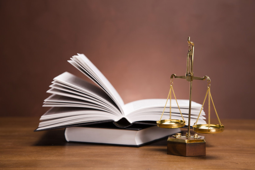Scales of justice and gavel on desk with dark background